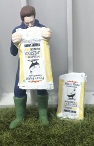 WM078K - Agricoltore che svuota un sacco di mangime per pollame